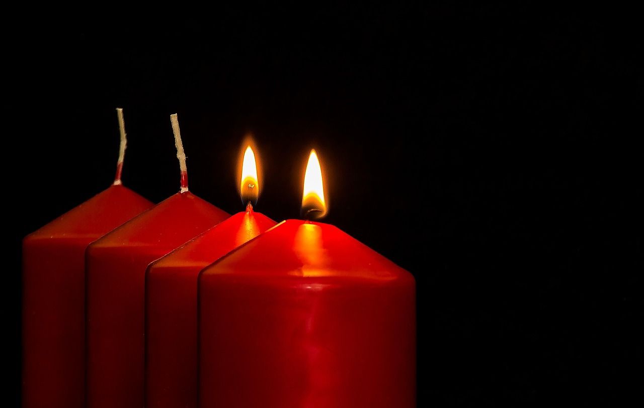 Red Memorial Candles with Two Flames Glowing Against a Dark Background