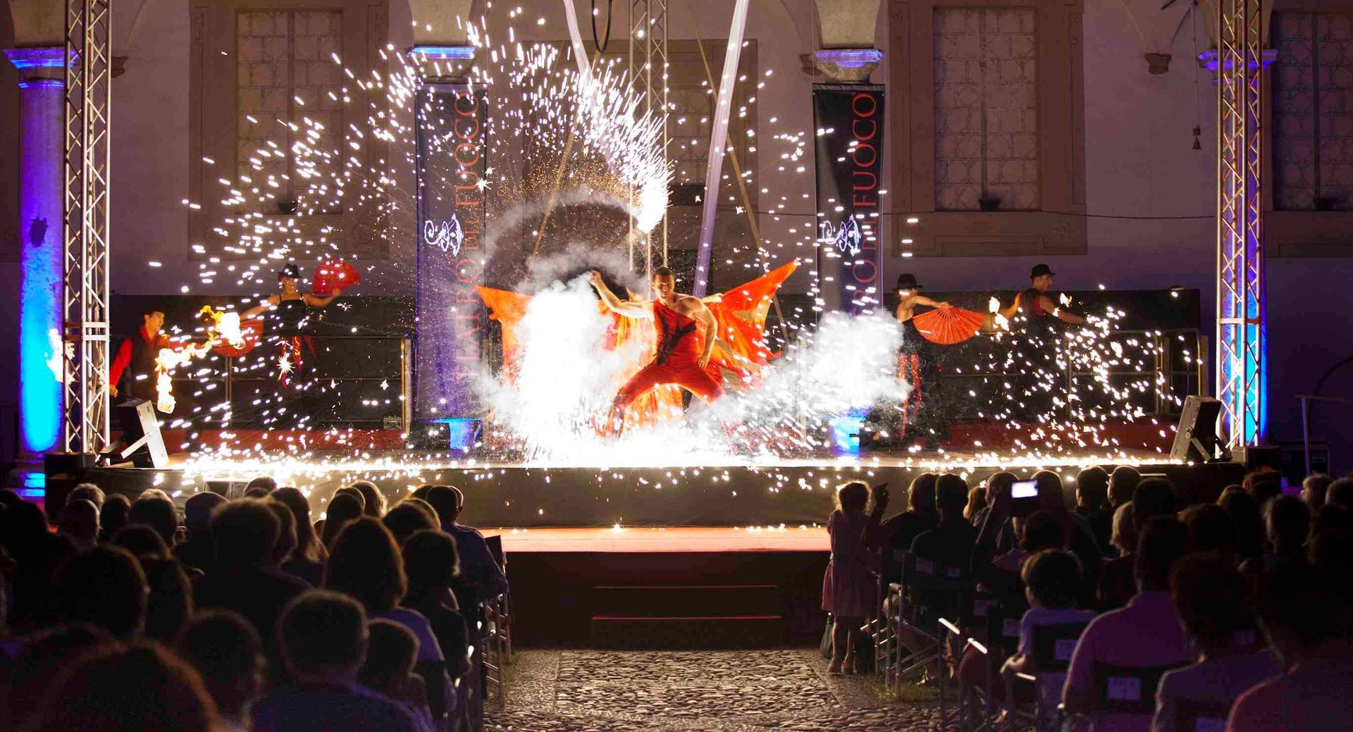 Un gruppo di persone sta guardando uno spettacolo pirotecnico su un palco.