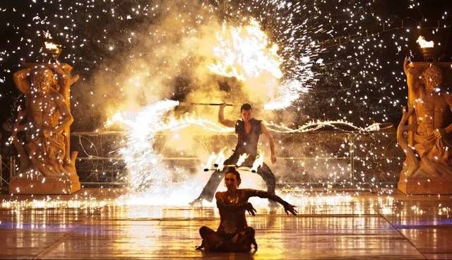 Un uomo e una donna stanno eseguendo uno spettacolo di fuoco su un palco.