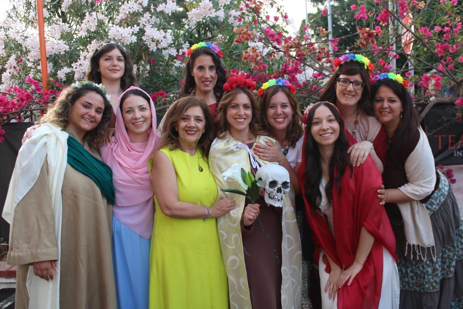 Un gruppo di donne posa per una foto con dei fiori tra i capelli.
