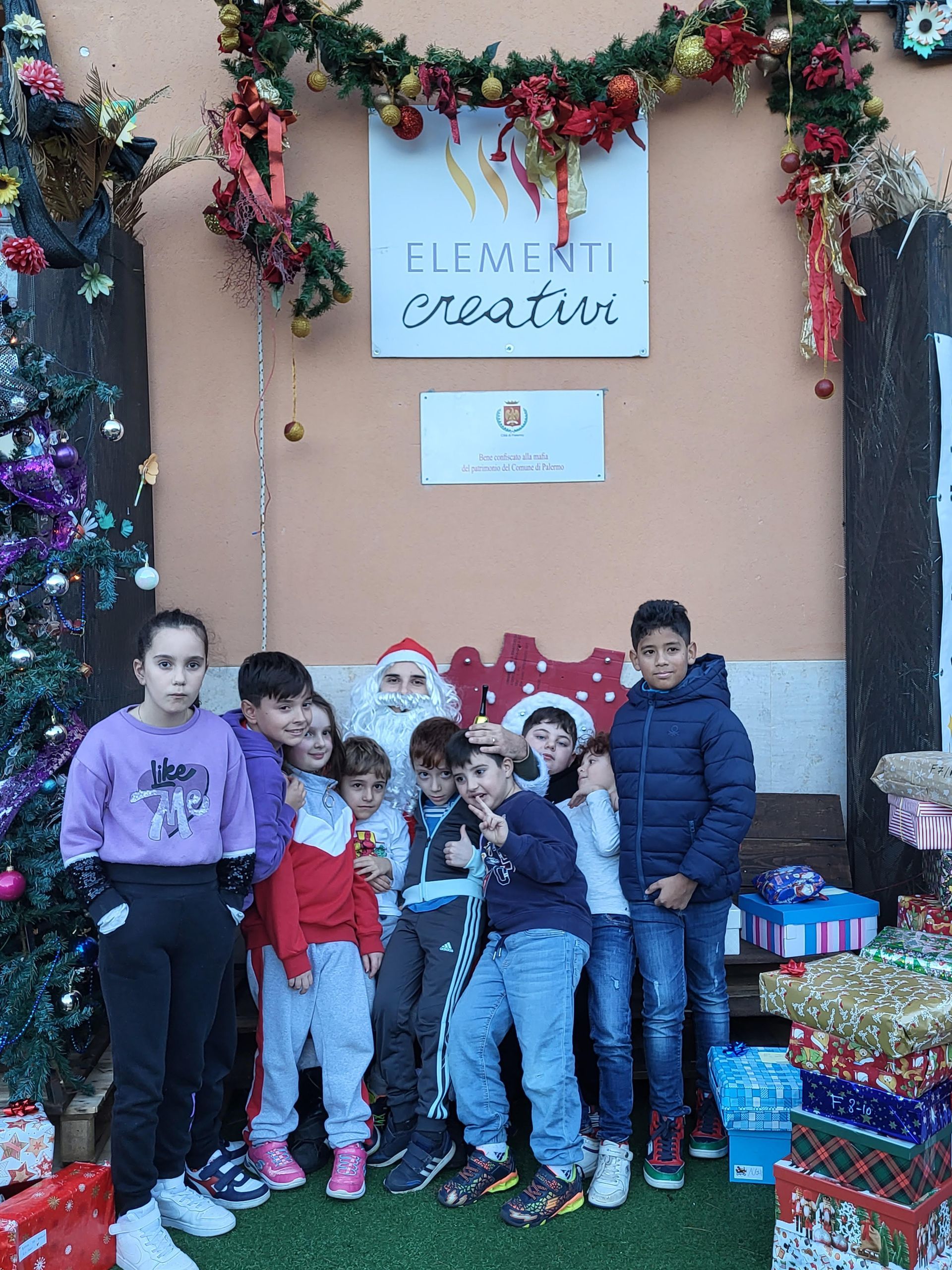 Un gruppo di bambini in piedi davanti a un cartello che dice elementi creativi