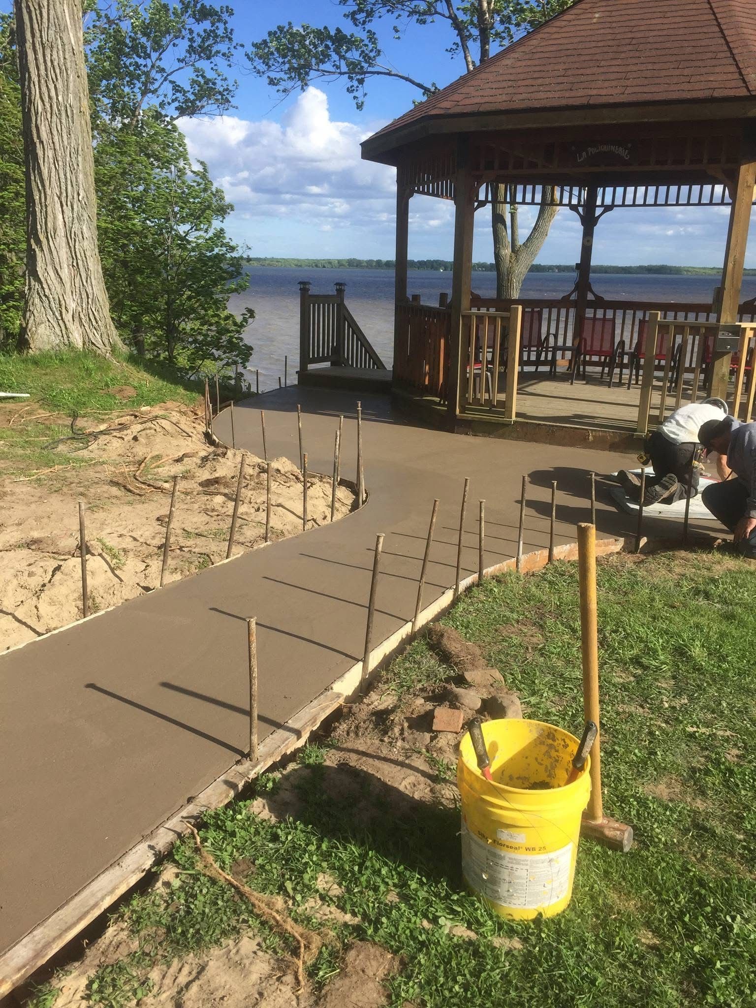 Un homme travaille sur une passerelle en béton à côté d'un belvédère.