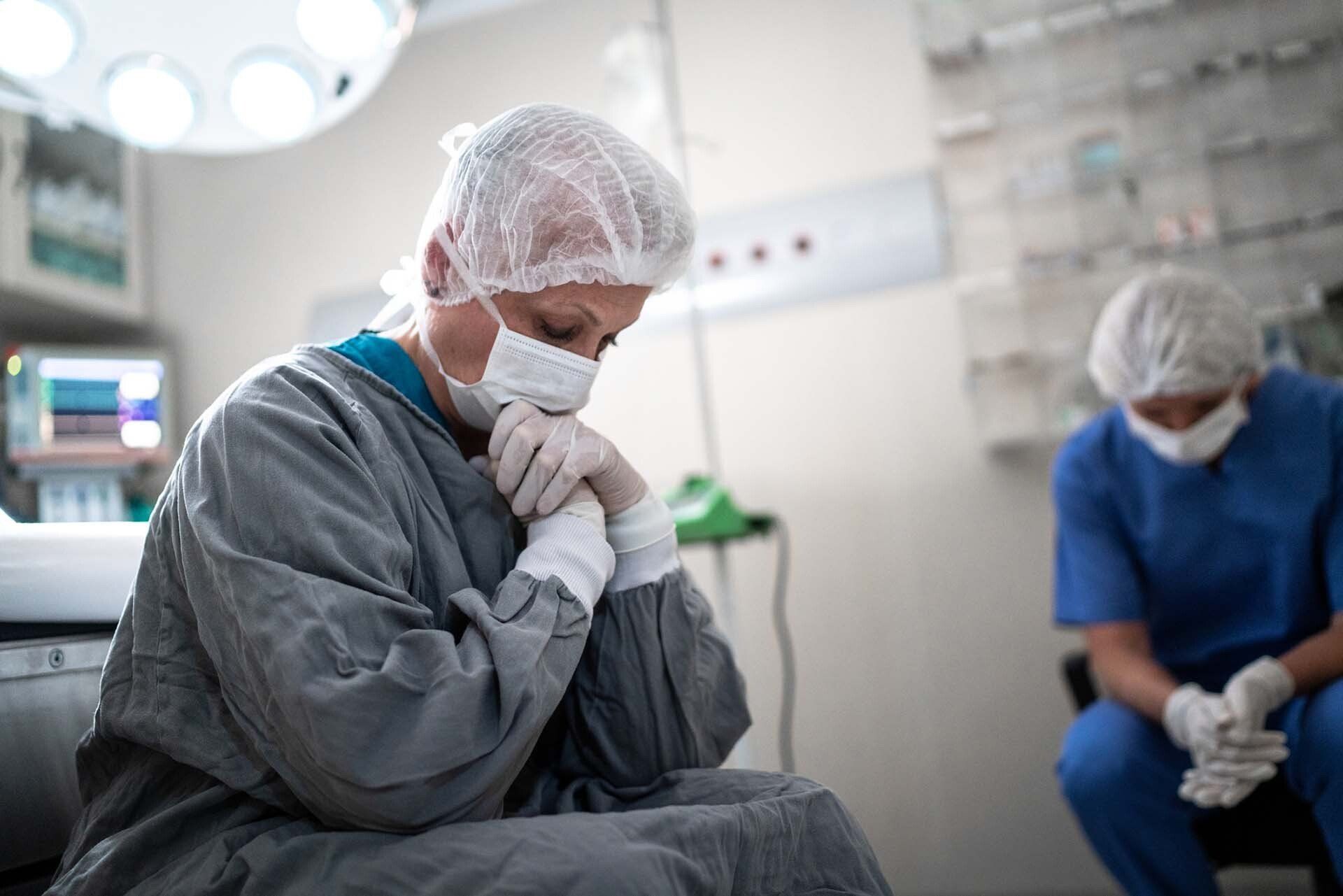 Worried Healthcare Co-Workers At Operating Room - Detroit, MI - Frederic M Rosen, PC Attorney At Law Two medical staff in surgical attire, heads bowed in a somber operating room.