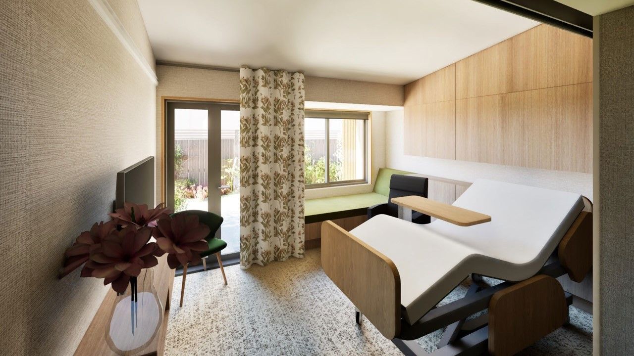 Hospital room interior with an adjustable bed, window, TV, and chair.