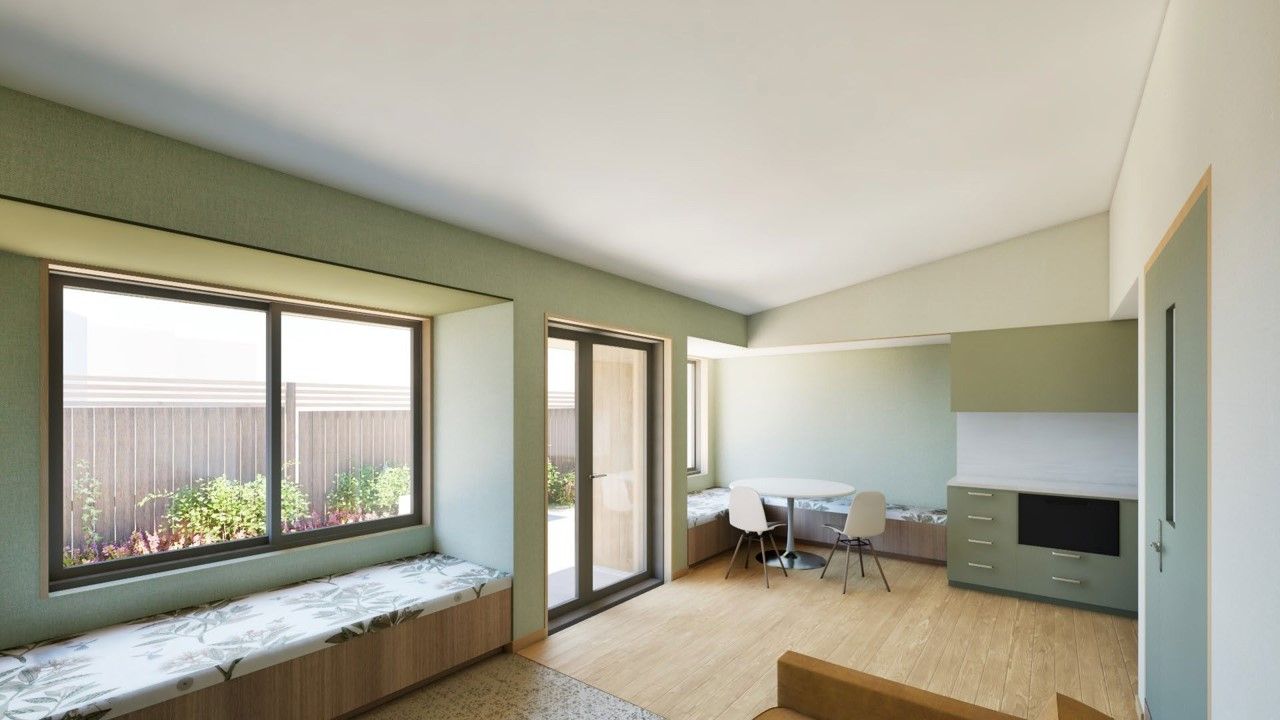 Interior of room with large window, dining area, and built-in storage, painted sage green.