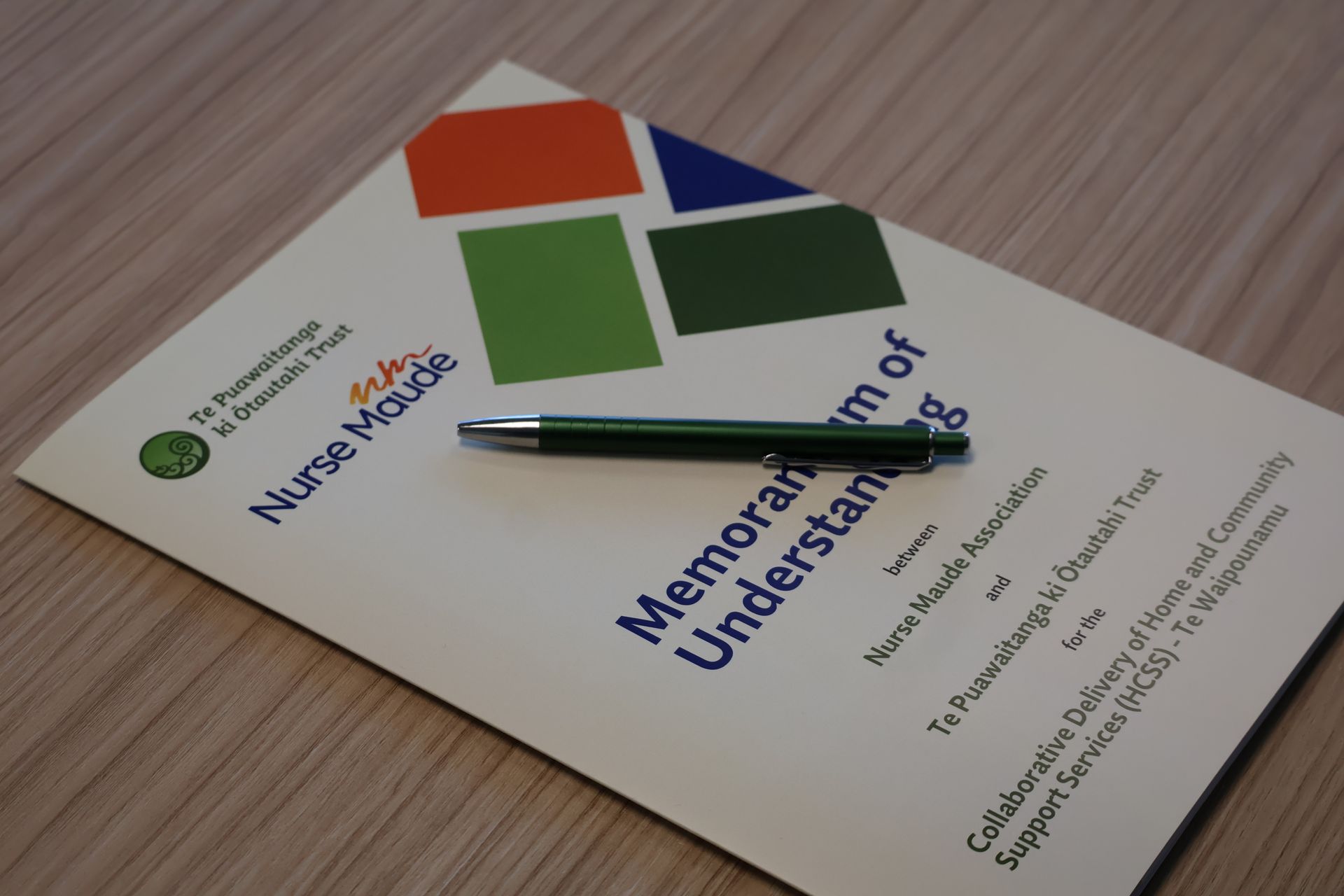 Handbook titled “Memory and Understanding” with a pen and colorful sticky notes on a wooden table