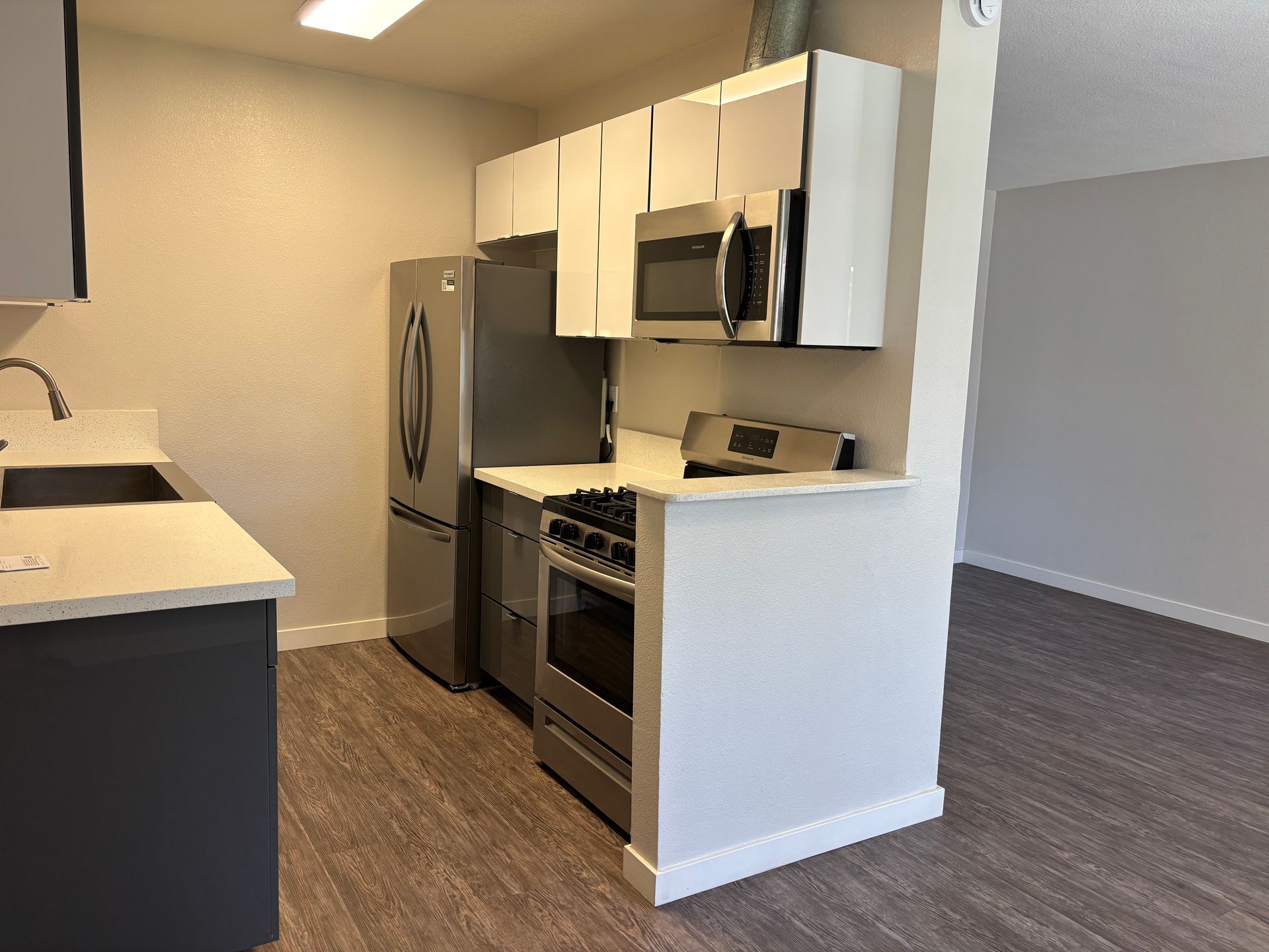 Kitchen showing updated appliances and the living room in the background