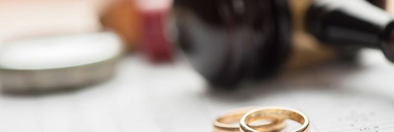Gavel laying next to two rings.