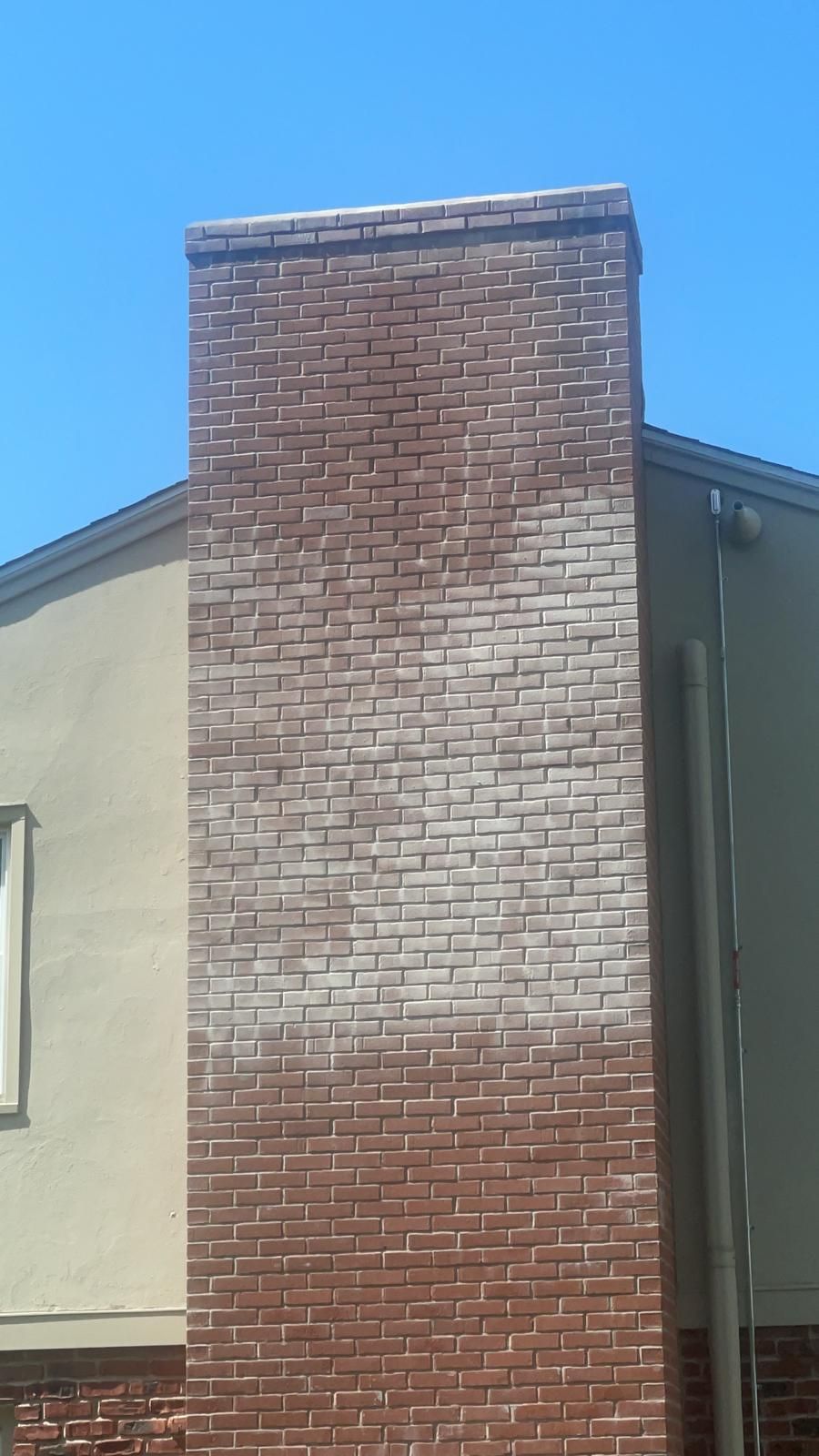 A brick chimney on the side of a building