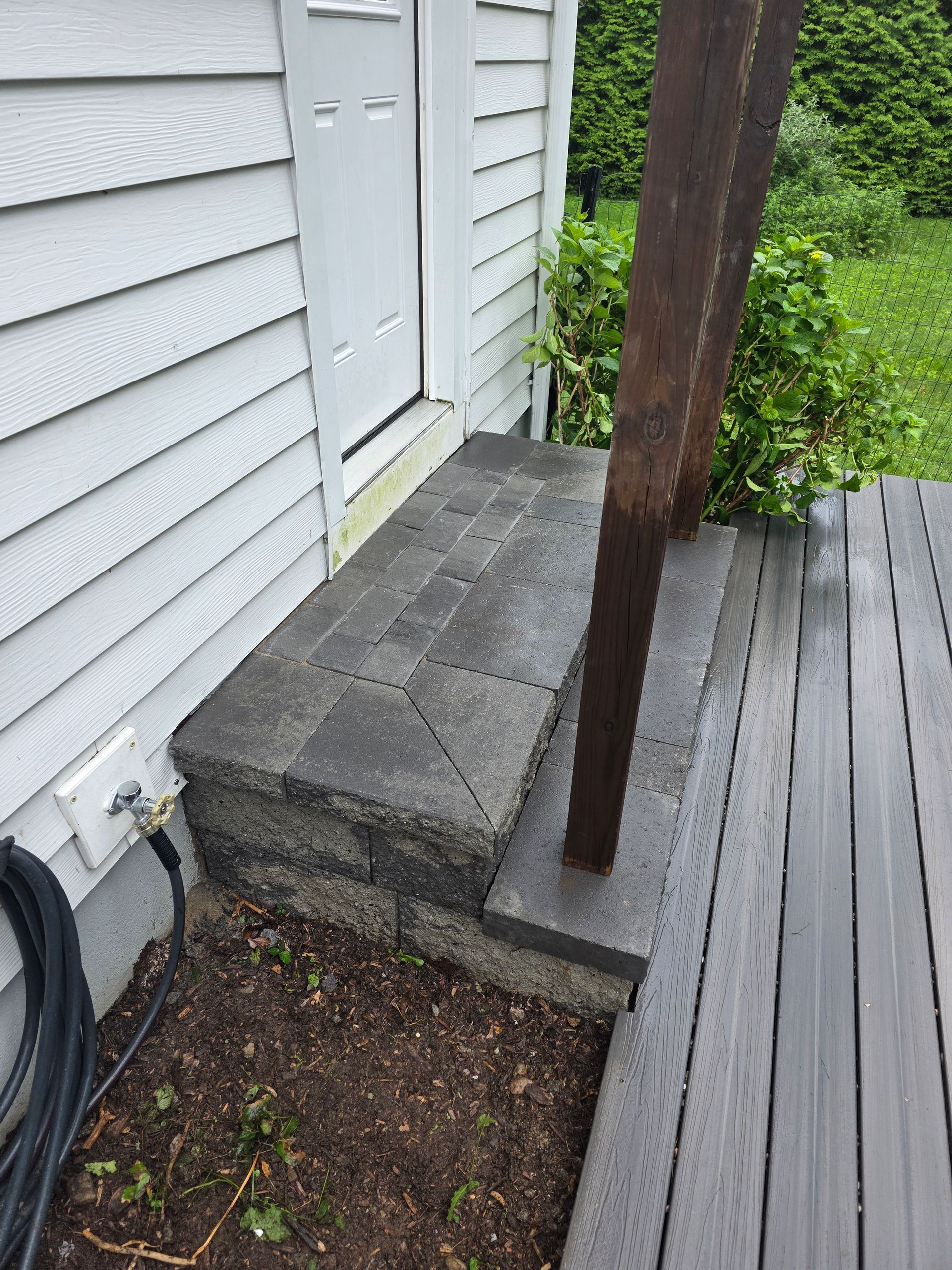 A wooden deck with stairs leading up to a house.