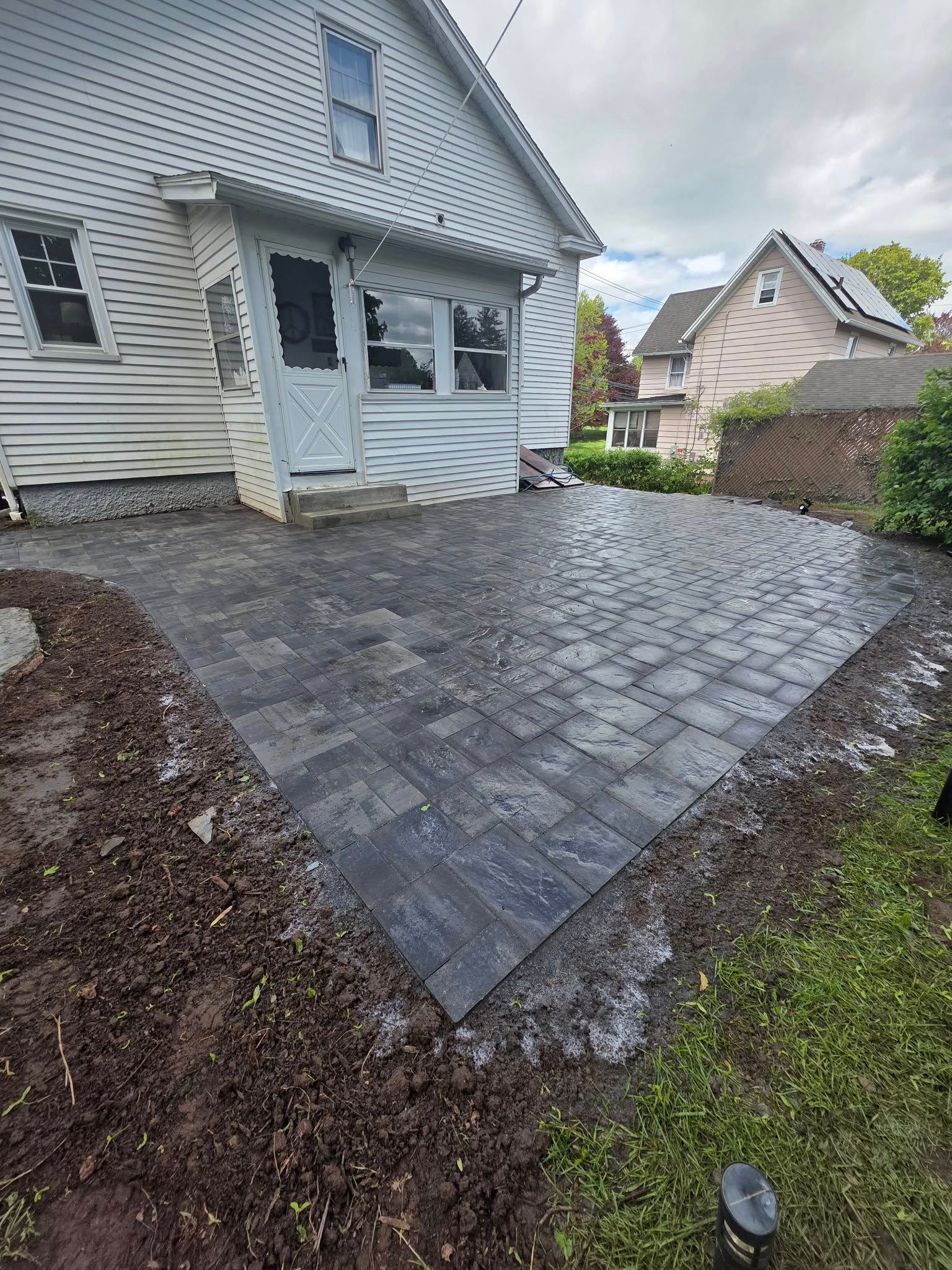 A patio is being built in front of a house.