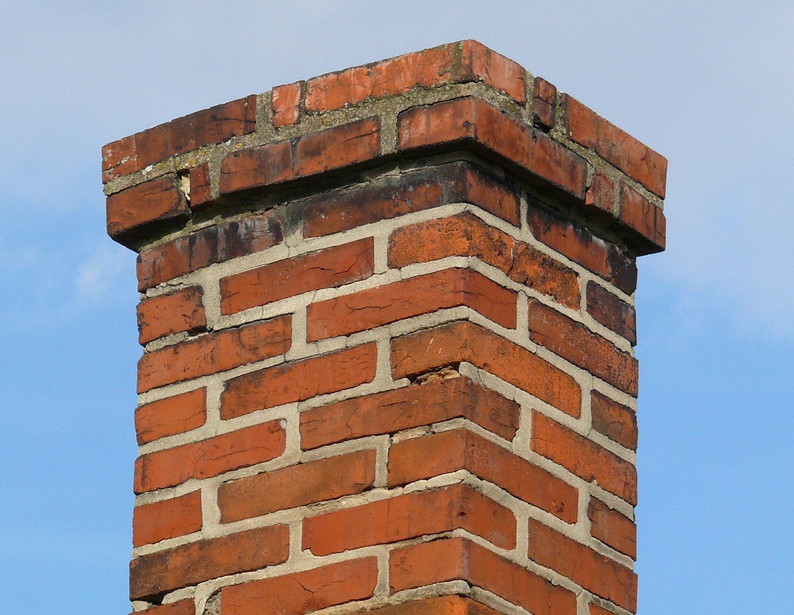 A brick chimney with a blue sky in the background