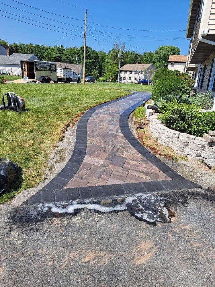 A brick walkway is being built in front of a house.