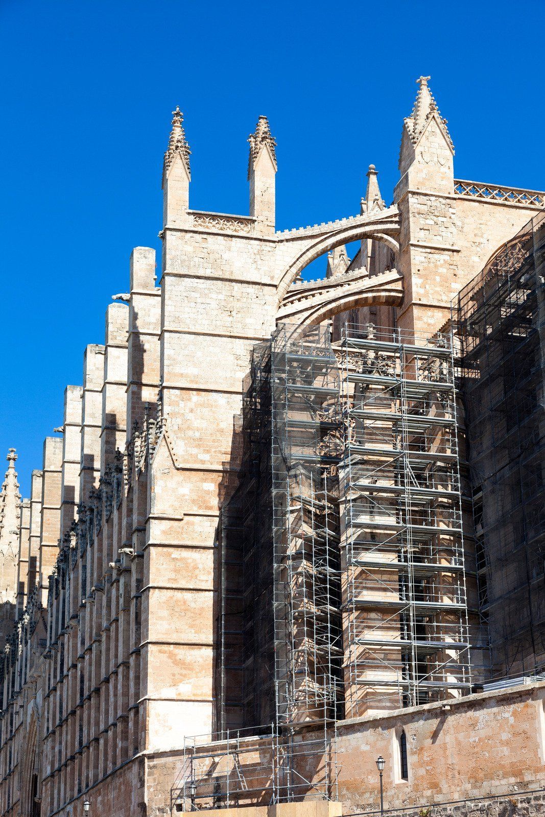 A large building with scaffolding around it and a blue sky in the background.