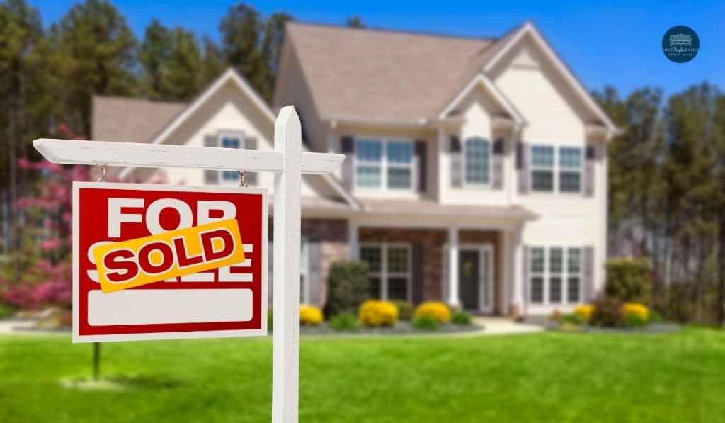A for sale sign is in front of a house.