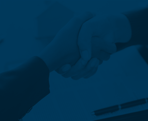 A person is shaking hands over a piece of paper with a pen.