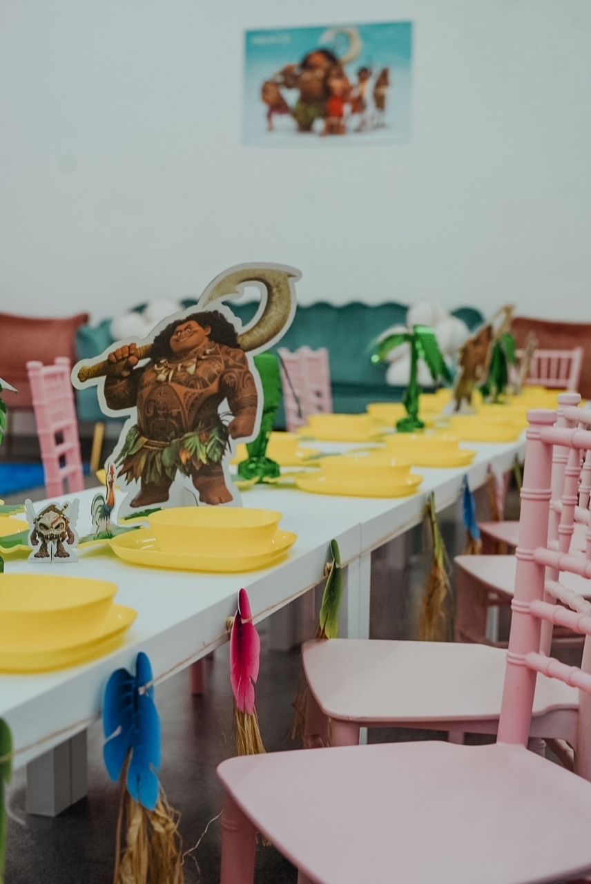 Decorated classroom tables with colorful animal cutouts and pink chairs in a party setup