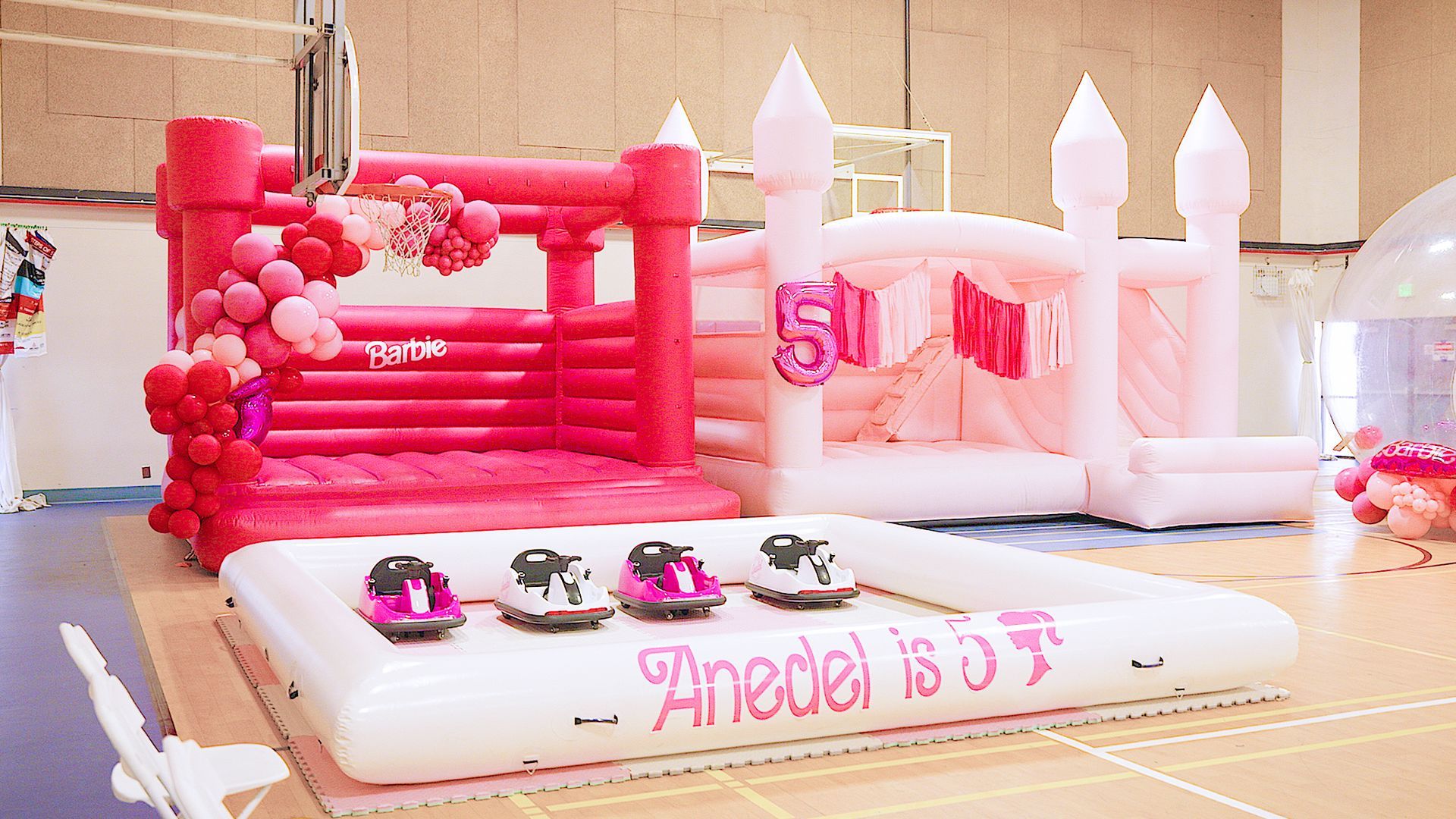 Pink inflatable castle cake with toy cars and “Anel is 3” birthday decoration