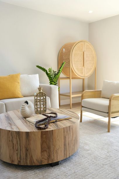 A bright living room features a round wooden coffee table. A bright living room features a round wooden coffee table.