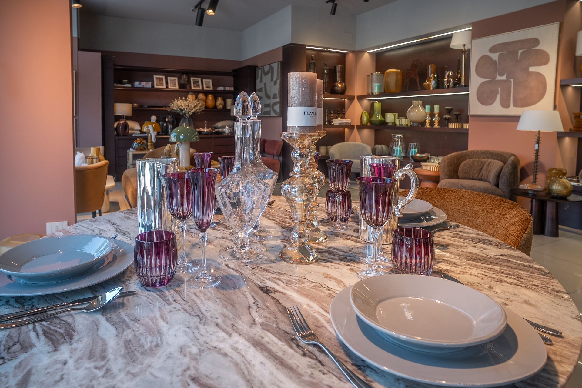 Elegante tavolo da pranzo apparecchiato con bicchieri e piatti di cristallo in un accogliente soggiorno moderno.