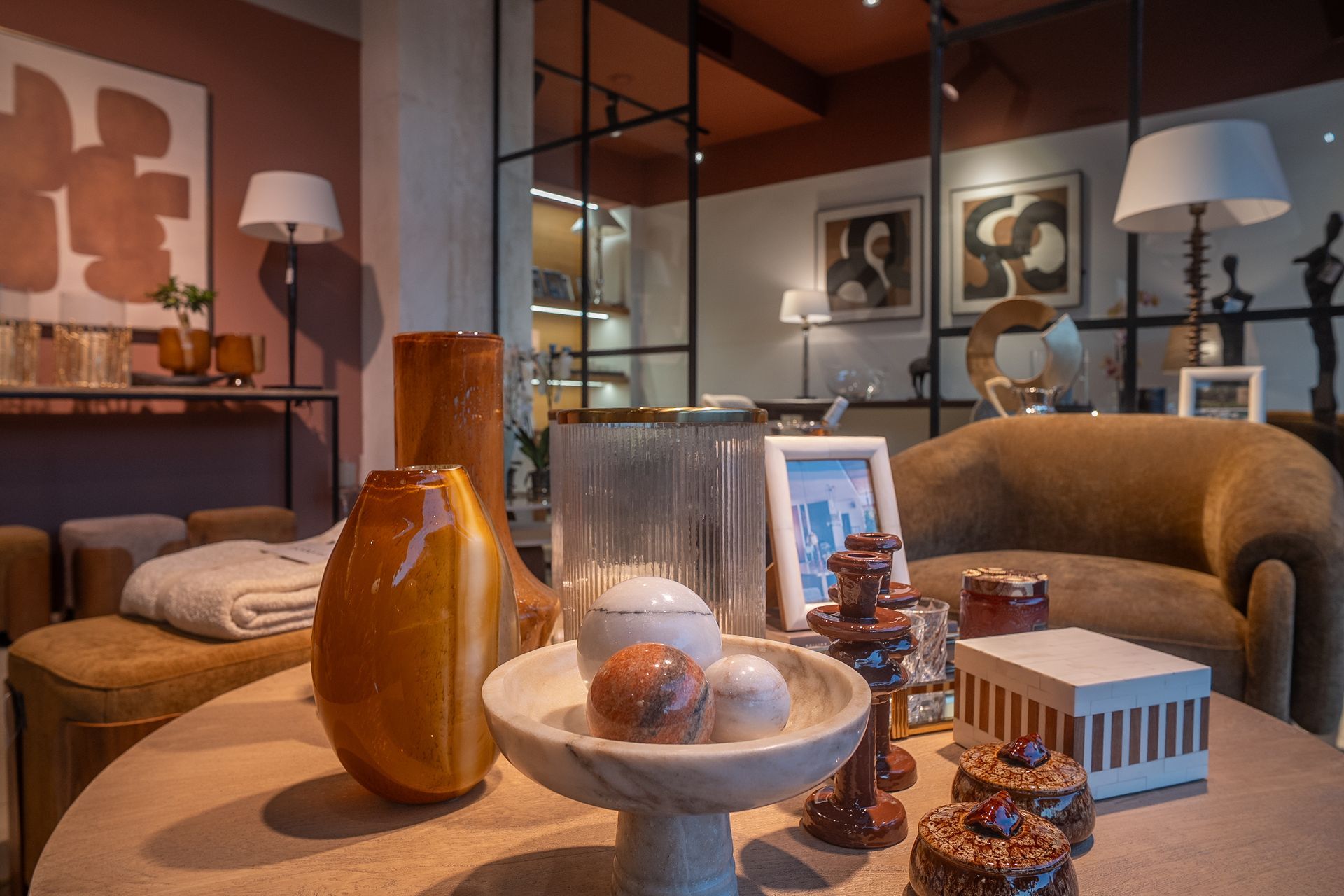 Accogliente soggiorno con divani beige, lampada, tavolino decorativo e quadri incorniciati alla parete.