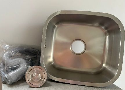 Fregadero de cocina de acero inoxidable con componentes de plomería.