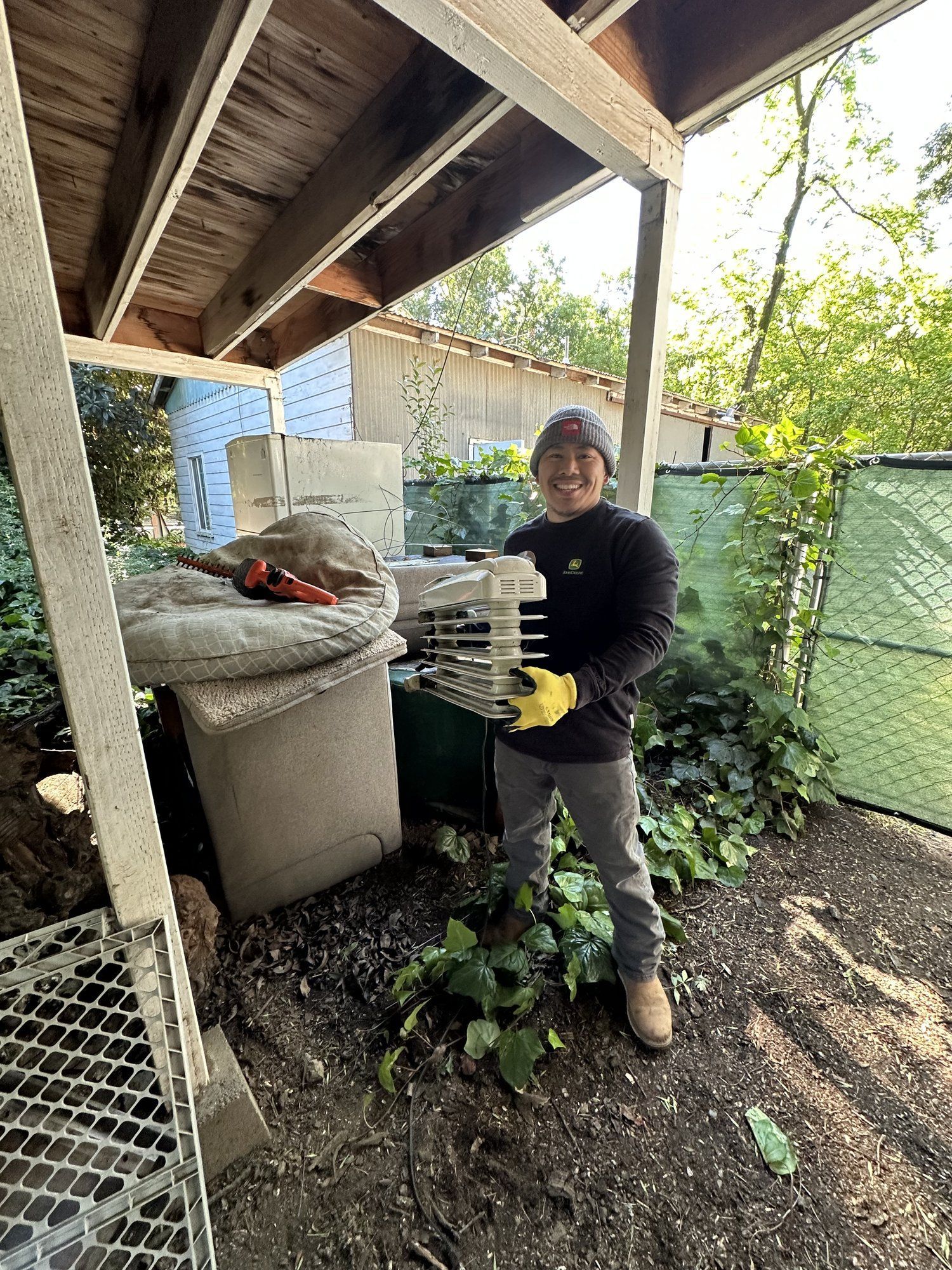 Crew member hauling yard debris from a covered patio during a cleanout
