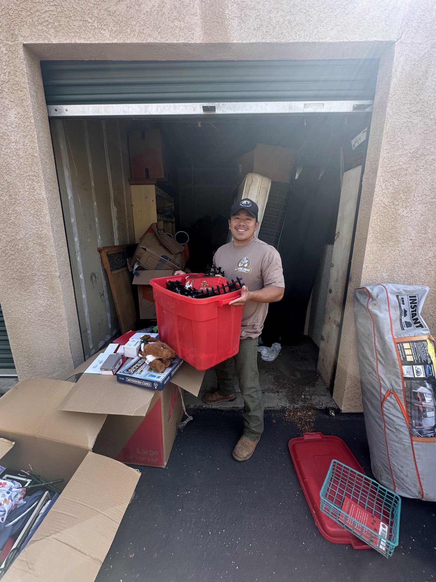 Crew member carrying items out of a storage unit during a storage cleanout