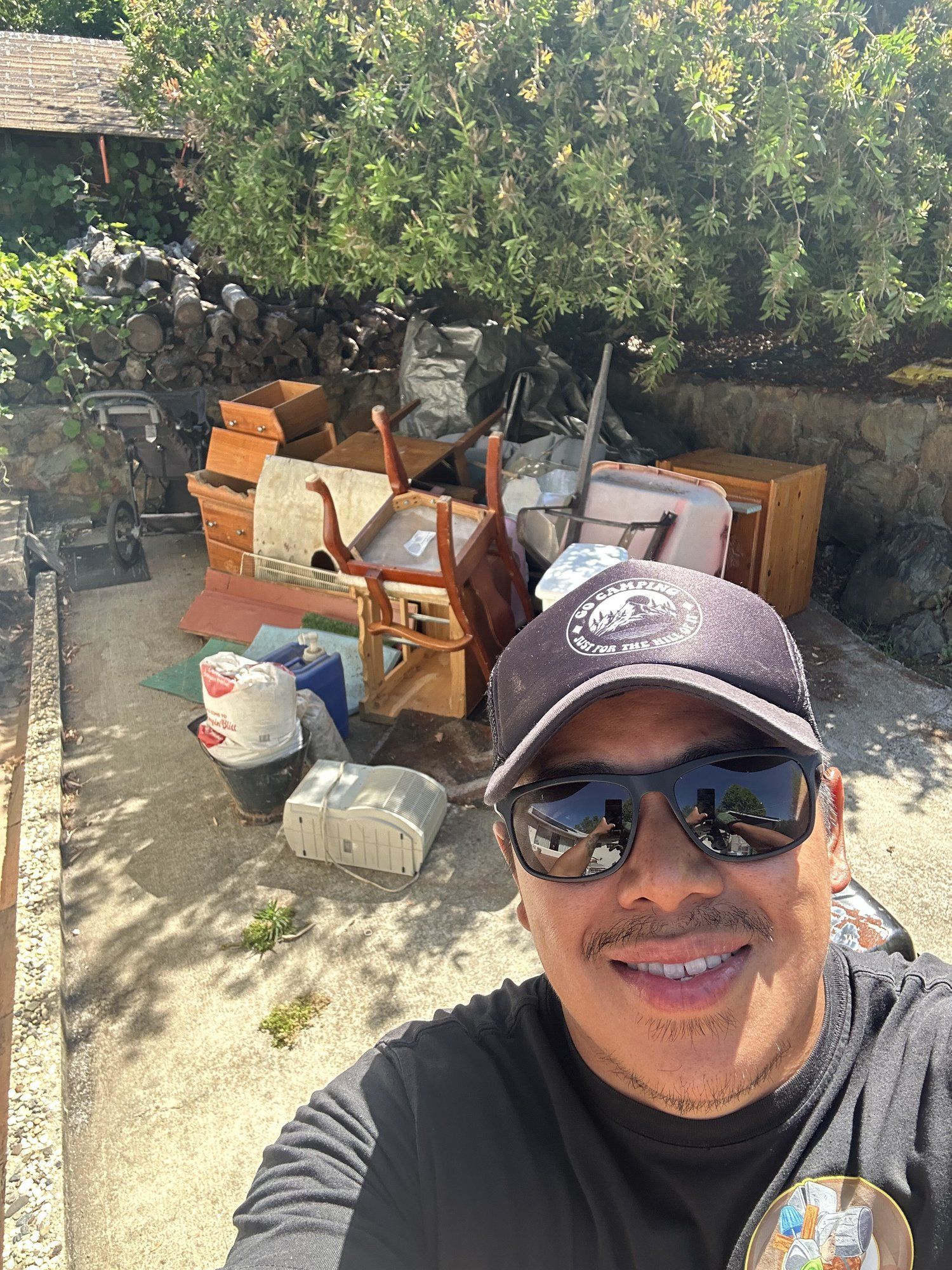 LJ Junk Away owner with a pile of furniture and junk ready for haul away