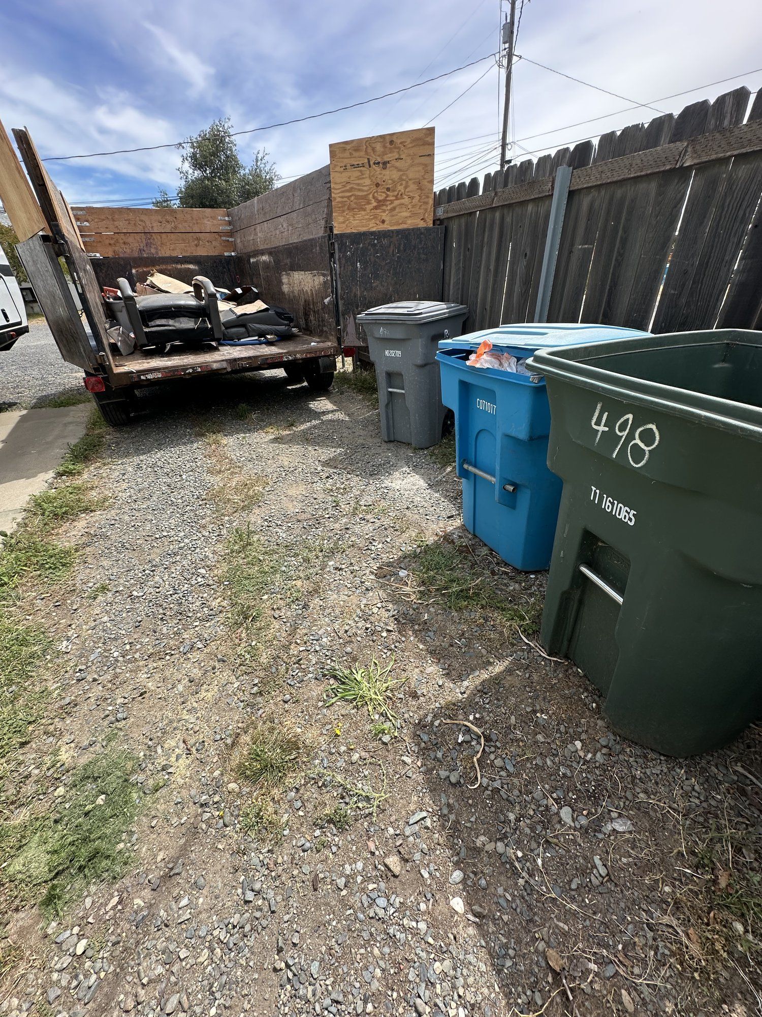 Trash bins and cleared driveway after a junk removal job