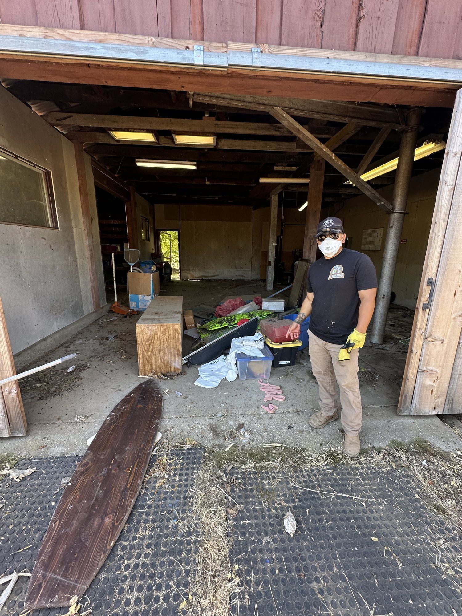 Crew member clearing a backyard shed during a cleanout