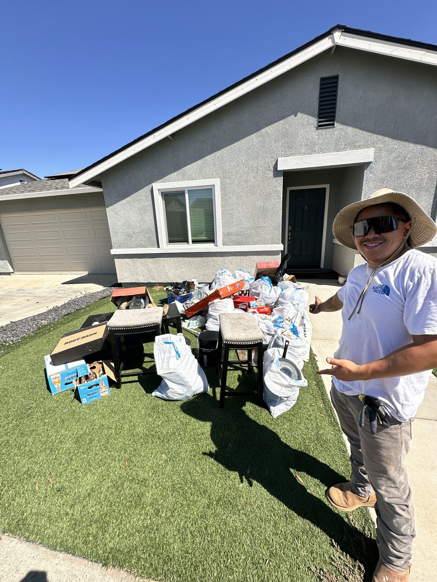 Curbside junk pile of bags and household items before pickup in Oroville