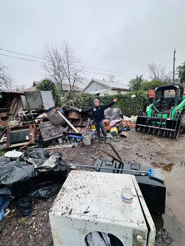 LJ Junk Away crew using a skid steer to clear demolition debris from a backyard in Oroville, CA