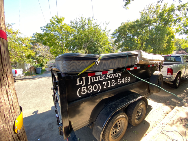 LJ Junk Away black junk removal trailer loaded with debris in Oroville, CA