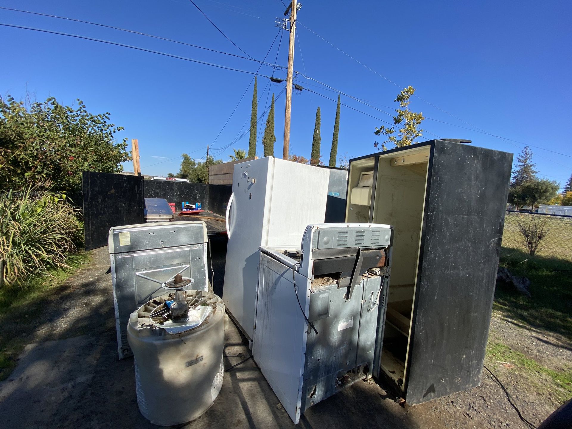 Old appliances and refrigerators staged for haul away
