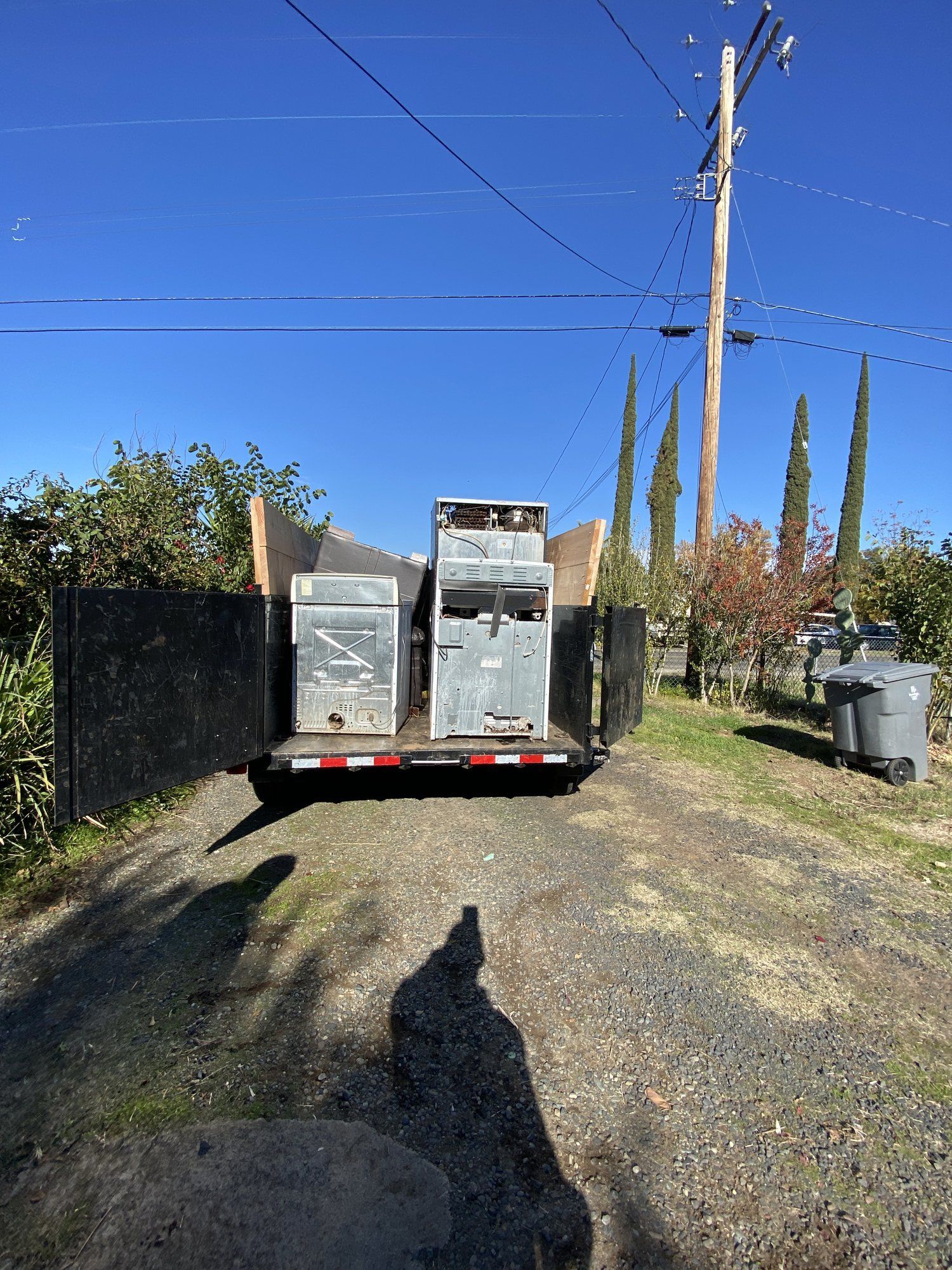 LJ Junk Away dump trailer loaded on a gravel road