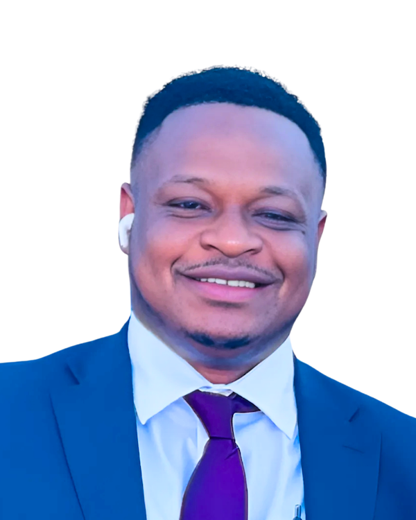 Man in a suit smiles, wearing a purple tie and a white earbud.