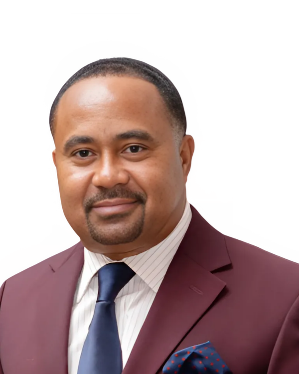 Man in a maroon suit and navy tie, smiling.