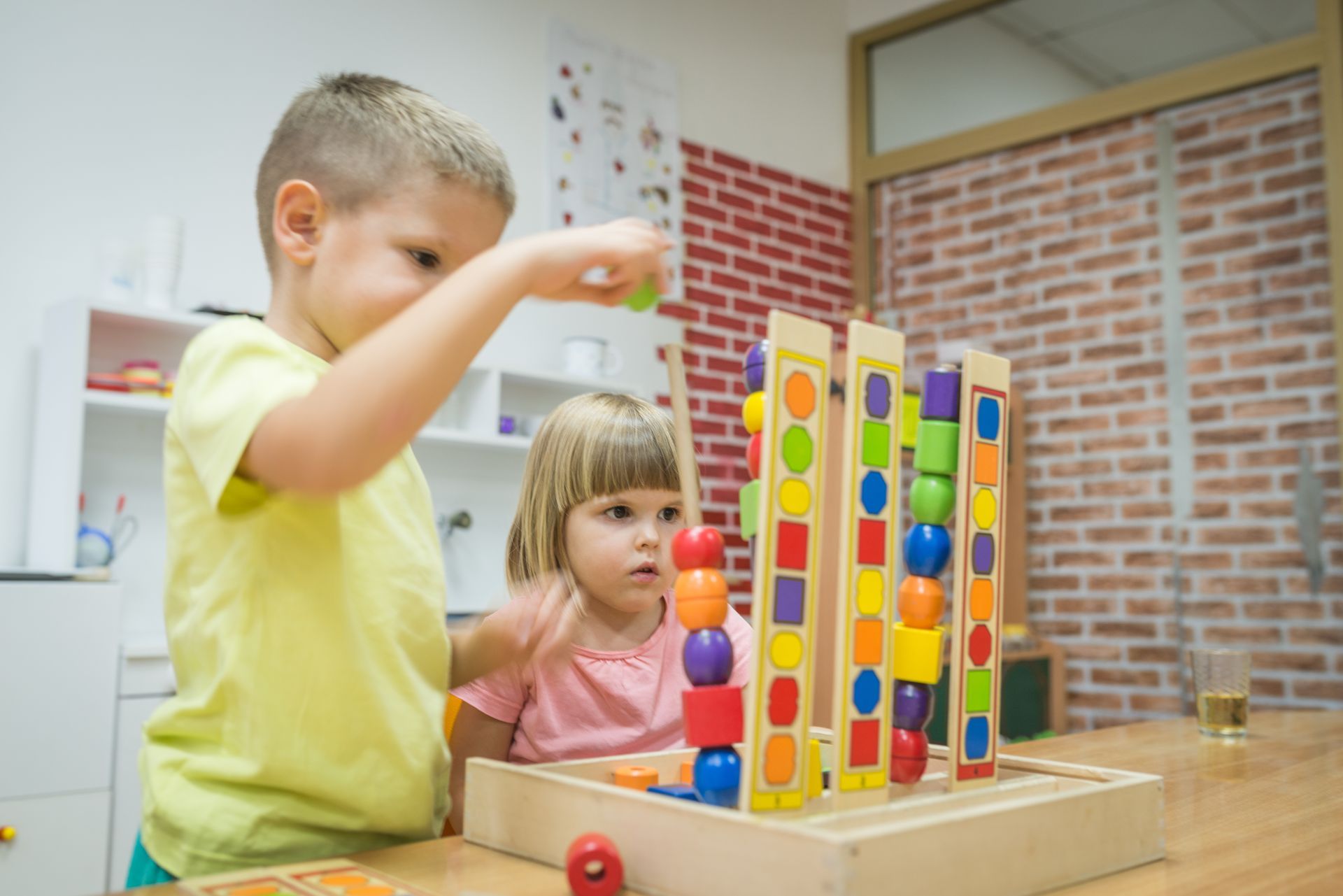 Pre-kindergarten students practicing color sorting and counting with a wooden toy Pre-kindergarten students practicing color sorting and counting with a wooden toy