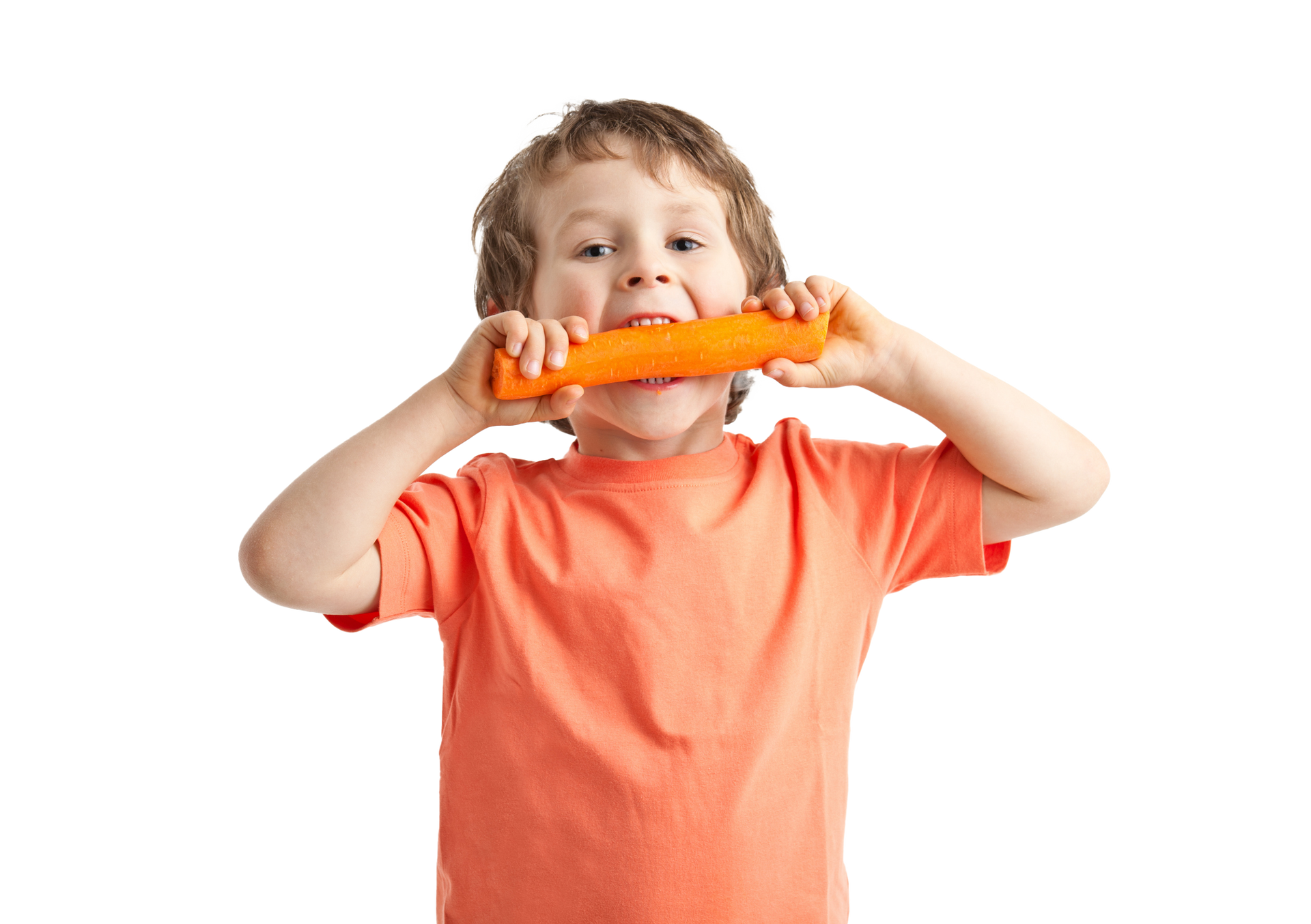 Boy with an orange shirt happily biting into a large carrot.