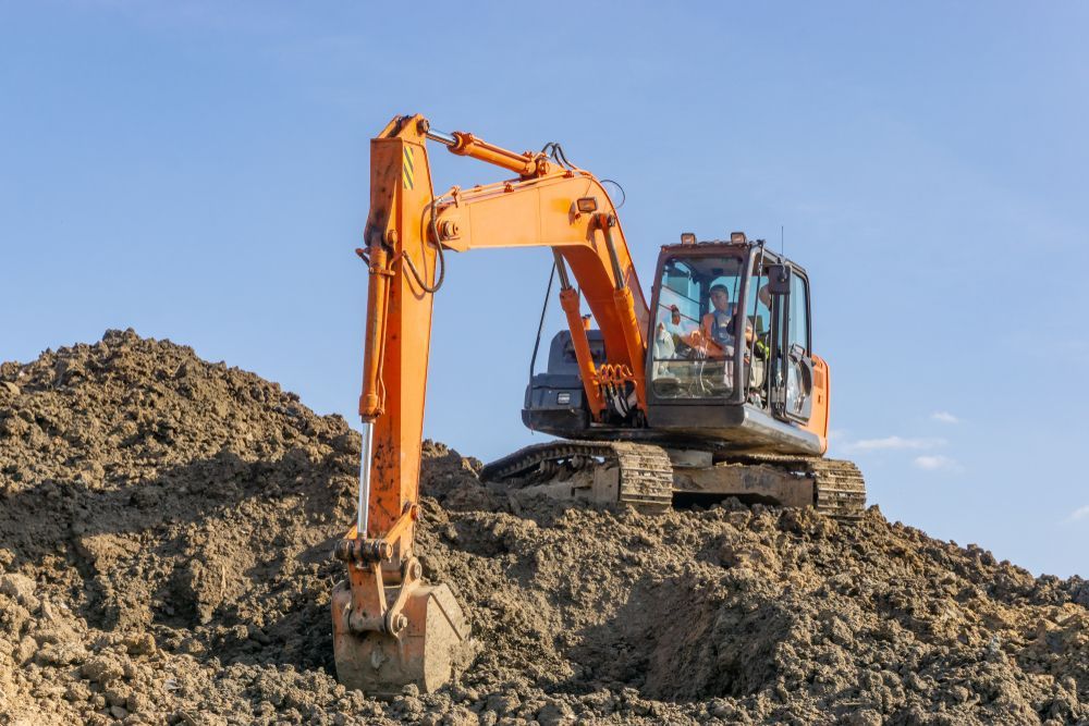 A Large Orange Excavator Is Sitting On Top Of A Pile Of Dirt — Territory Industries Pty Ltd In Larrimah, NT