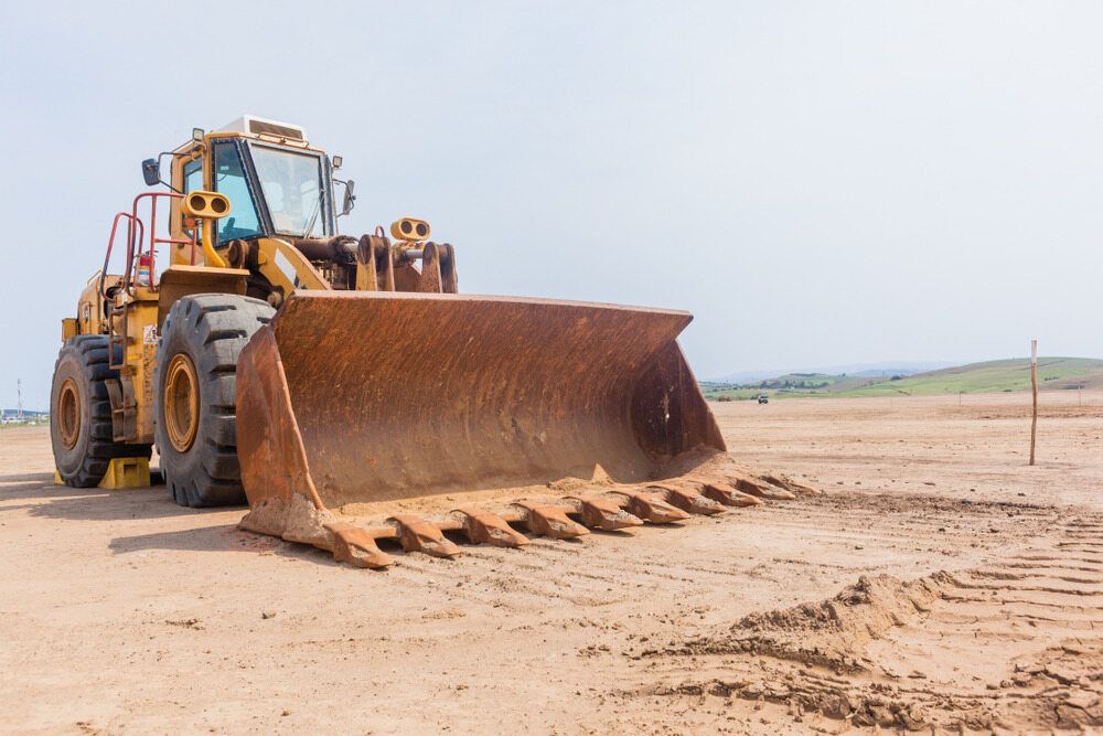 A Bulldozer Is Sitting In The Middle Of A Dirt Field — Territory Industries Pty Ltd In Larrimah, NT