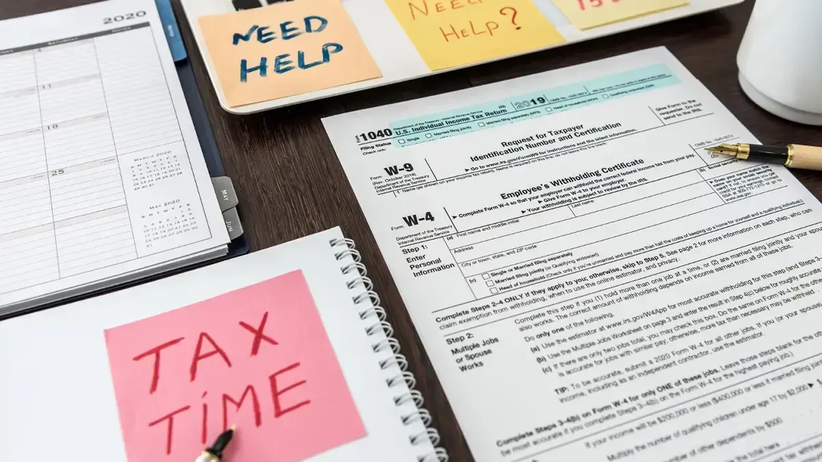 Tax financial forms with pen and calculator and sticker with text tax time.