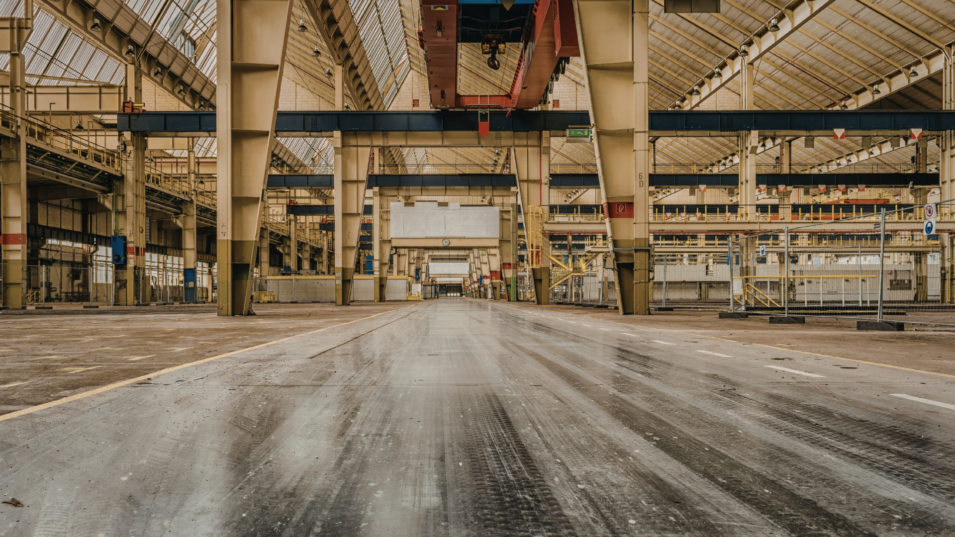Abandoned industrial warehouse interior with concrete pillars and dusty floor