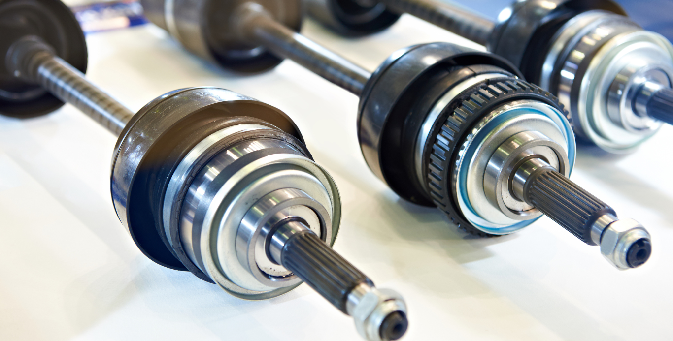 A group of drive shafts are sitting on top of each other on a table.