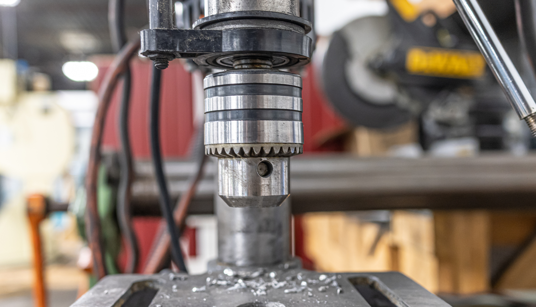 A close up of a drill bit on a machine in a factory.