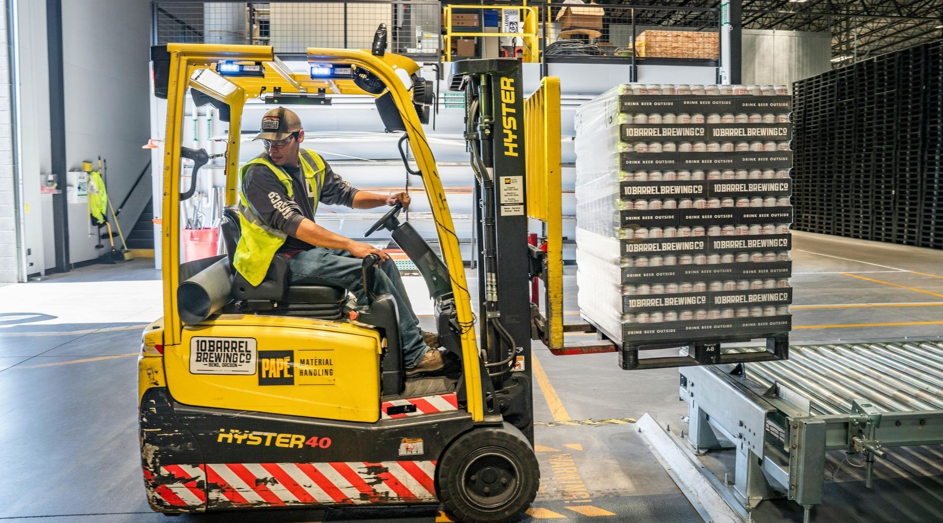 A man is driving a forklift in a warehouse.