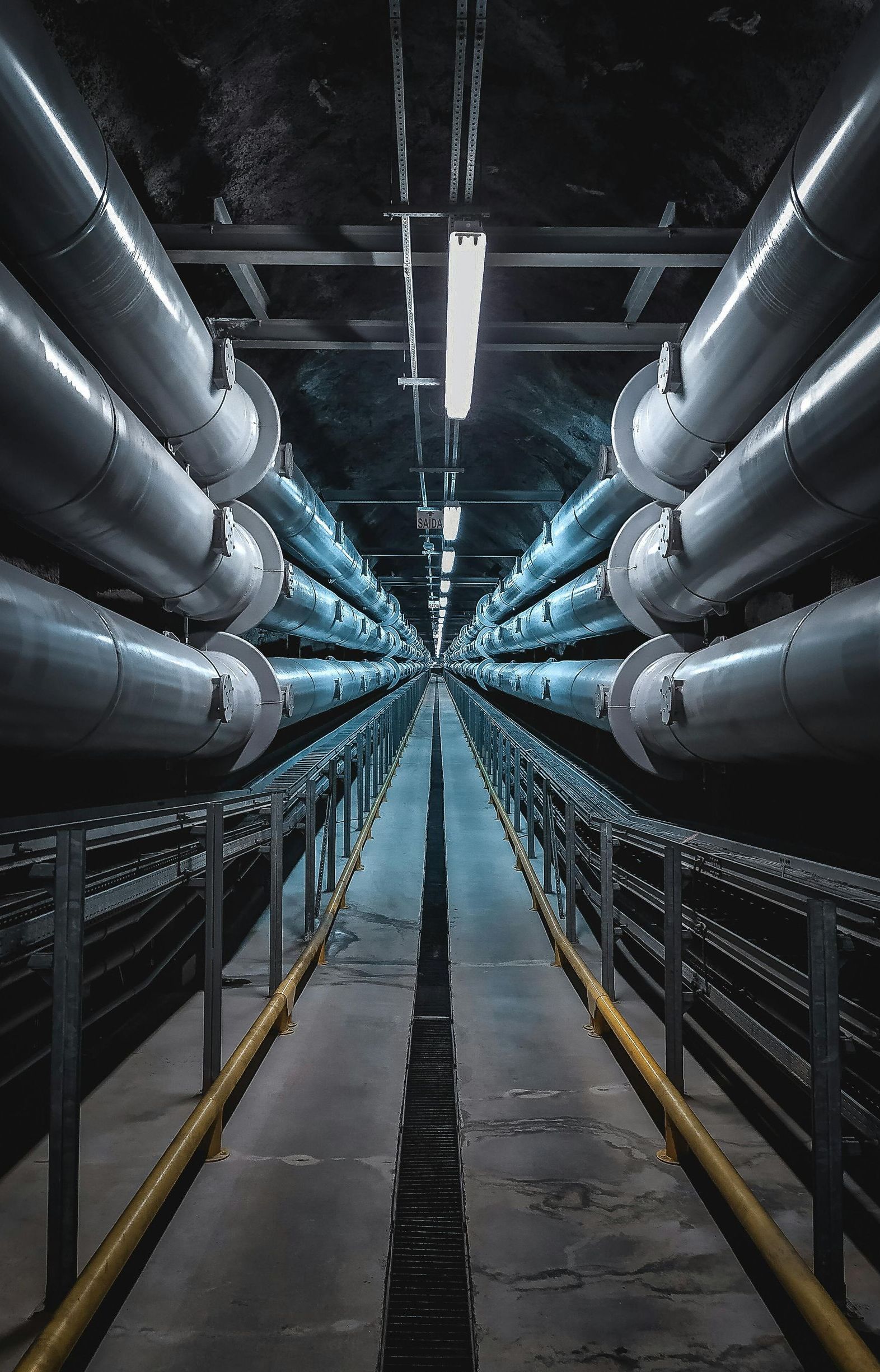 A tunnel filled with lots of pipes going through it.