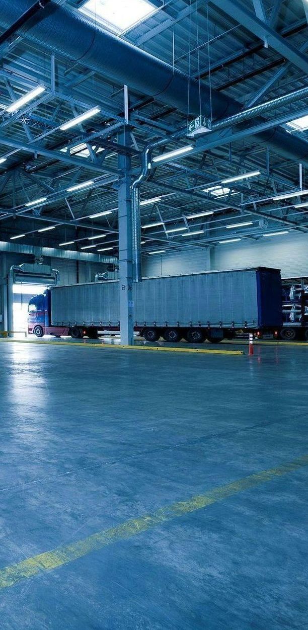 A large warehouse with a lot of trucks in it.