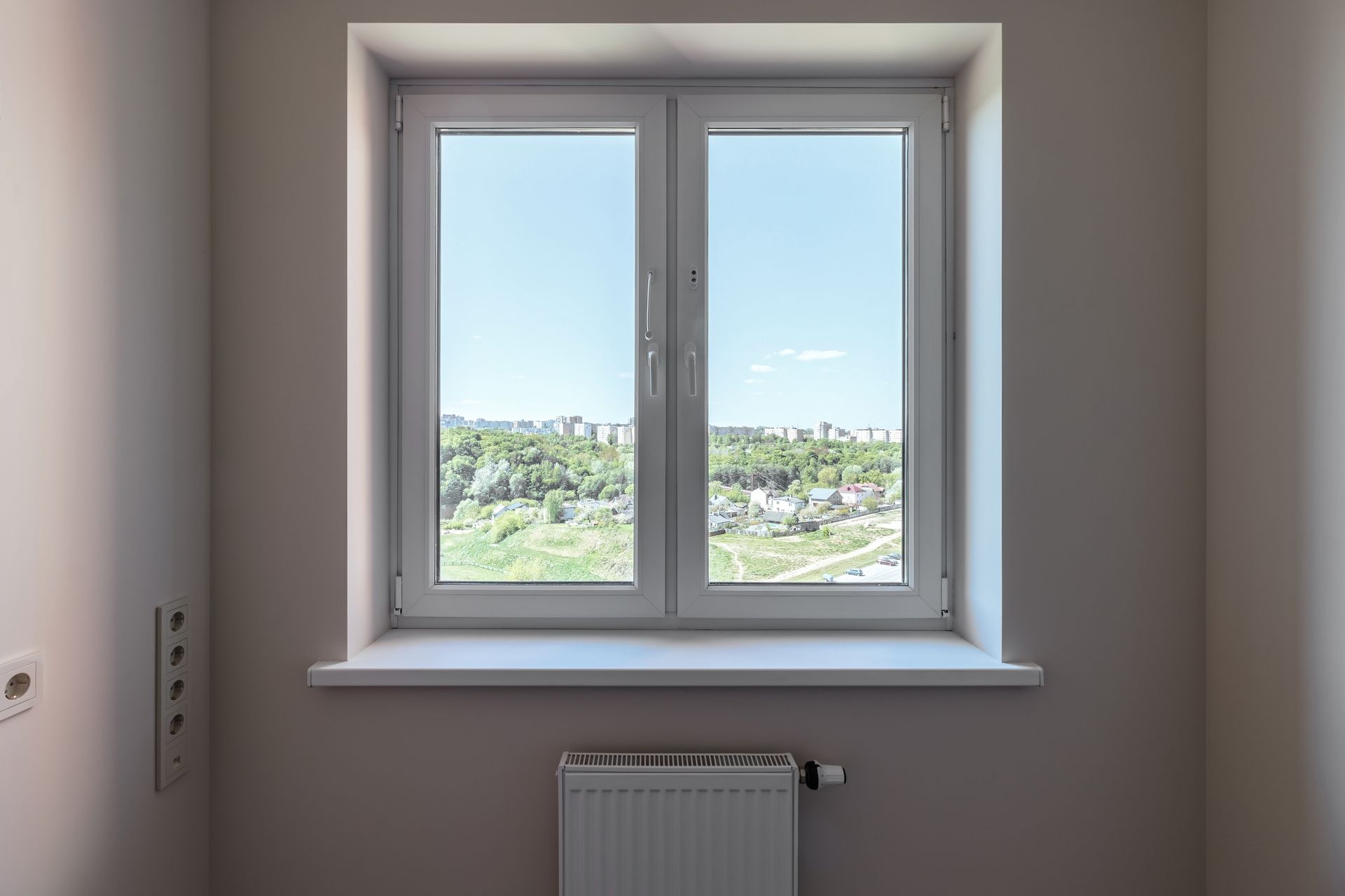 An empty room with a window and a radiator.